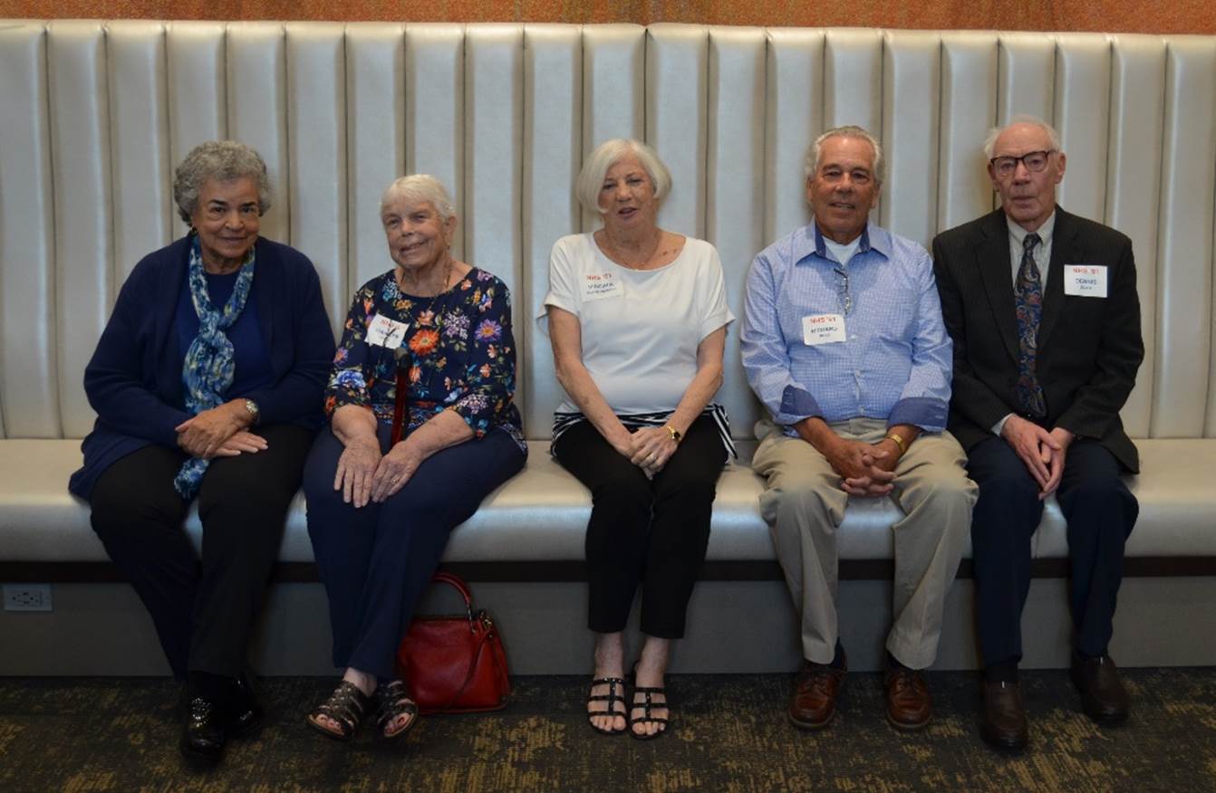 A group of people sitting on a bench

Description automatically generated